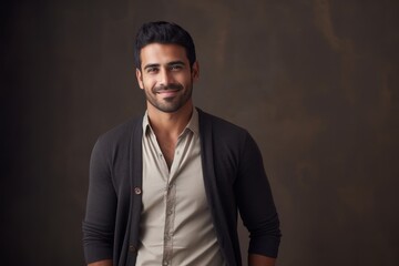 Obraz premium Portrait of a handsome young man smiling at camera on dark background