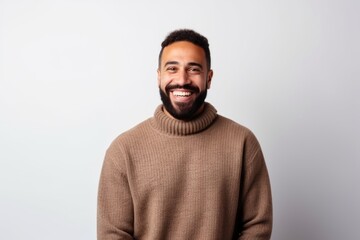 Portrait of a happy young man in a sweater standing against a white background