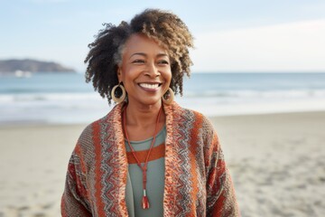 Portrait of a smiling young woman standing on the beach in autumn