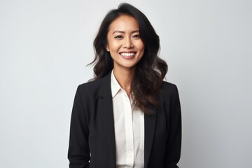 Portrait of a smiling young businesswoman standing over white background.