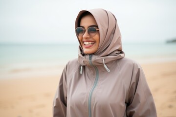 Portrait of a happy muslim woman wearing sunglasses on the beach