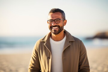 portrait of smiling man with eyeglasses on beach in autumn