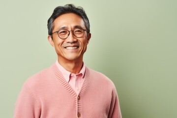 Portrait of a smiling asian man wearing pink sweater and glasses