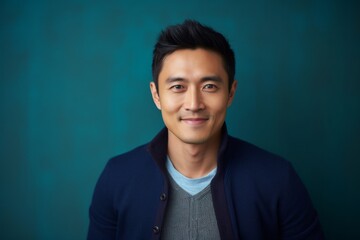 Medium shot portrait photography of a satisfied Chinese man in his 30s wearing a chic cardigan against an abstract background 
