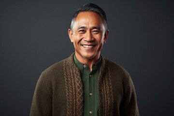 Obraz premium Portrait of happy mature Asian man smiling at camera against grey background