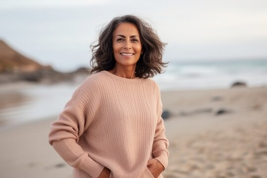 Portrait of a beautiful young woman smiling at the camera on the beach