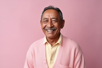 Medium shot portrait photography of a happy Indonesian man in his 50s wearing a chic cardigan against a pastel or soft colors background 