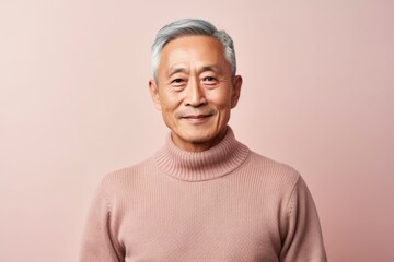 Portrait of an asian senior man isolated on a pink background