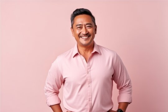 Portrait of a smiling asian man in pink shirt on pink background