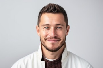 Portrait of a handsome young man smiling on a white background.