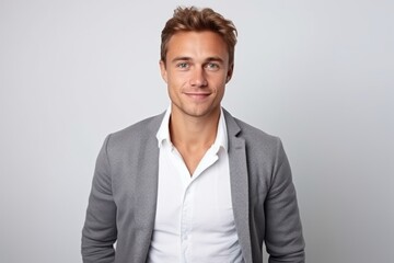 Portrait of handsome young man with blond hair smiling at camera.