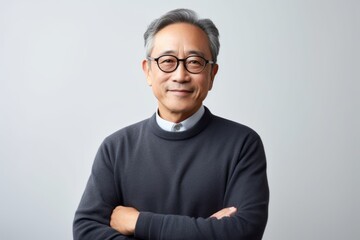 Portrait of Asian senior man in eyeglasses on grey background