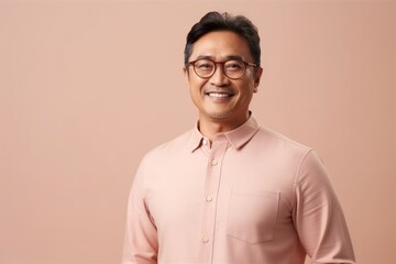 Portrait of a smiling Asian man in pink shirt and eyeglasses