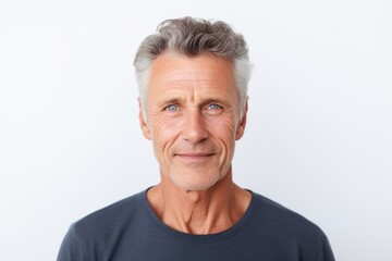 Obraz premium Thoughtful mature man looking at camera while standing against white background