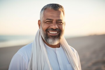 Portrait of a smiling middle-aged muslim man standing on the beach