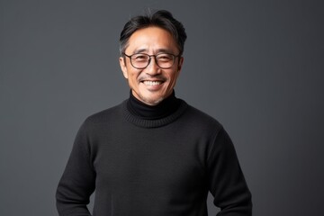 Obraz premium Portrait of a smiling asian man in black sweater and glasses