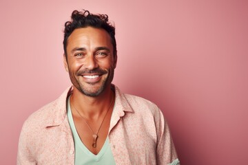 Obraz premium Portrait of a handsome young man smiling against a pink background.