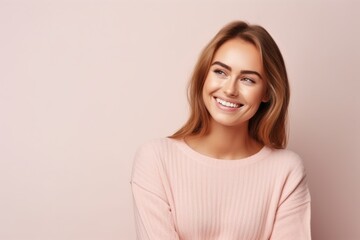 Portrait of a beautiful young woman smiling at camera on a pink background