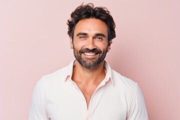 Fototapeta premium Portrait of a handsome young man smiling at the camera on a pink background