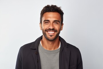 Obraz premium Portrait of a handsome young man smiling and looking at camera over white background