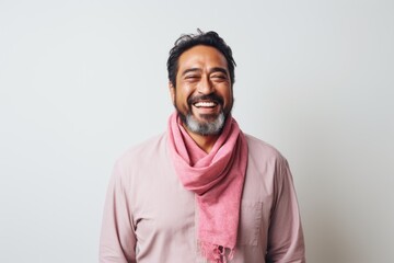 Portrait of a smiling Indian man wearing pink scarf against white background
