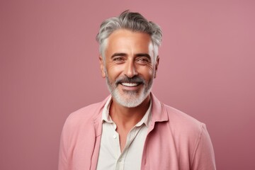 Obraz premium Portrait of smiling mature man looking at camera isolated on pink background