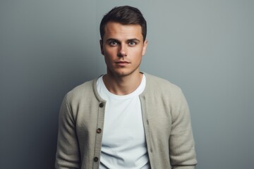 Obraz premium Handsome young man in casual clothes looking at camera while standing against grey background
