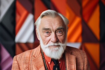 Portrait of a senior man with a white beard in an orange jacket.