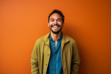 Fototapeta premium Portrait of a happy young african american man on orange background