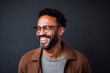 Fototapeta premium Portrait of a happy african american man in eyeglasses on black background