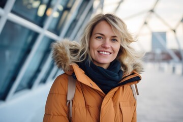 Portrait of a beautiful woman with blond hair in an orange jacket.
