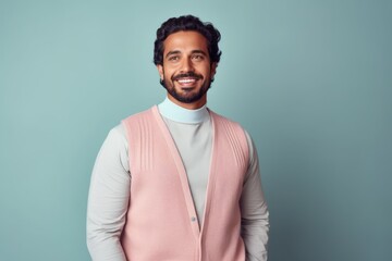 Obraz premium Portrait of a handsome young bearded Indian man standing against blue background