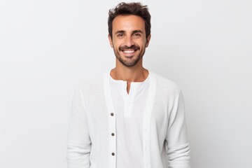 Obraz premium Portrait of a handsome young man smiling at the camera while standing against white background