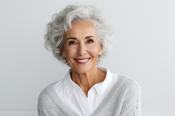Group portrait photography of a satisfied Brazilian woman in her 70s wearing a chic cardigan against a white background 