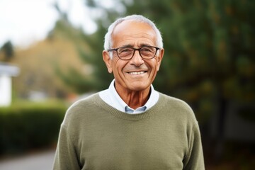 Medium shot portrait photography of a happy Brazilian man in his 70s wearing a chic cardigan against a white background 