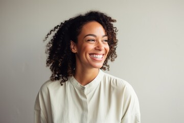 Portrait of beautiful young african american woman smiling against grey background
