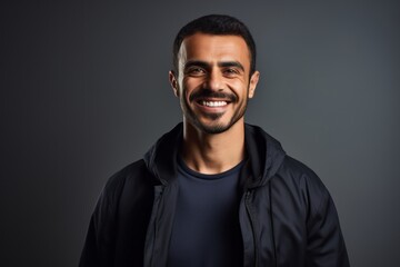 Fototapeta premium Portrait of a handsome young man smiling at camera isolated on grey background
