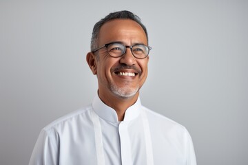 Portrait of mature Indian man in eyeglasses smiling at camera