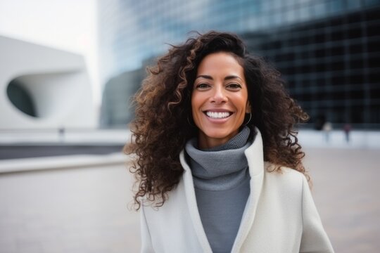 Portrait of smiling woman with curly hair in coat in the city