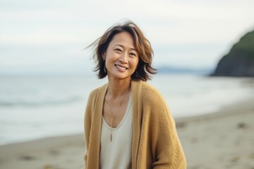 Portrait of happy Asian woman smiling and looking at camera on the beach