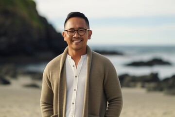 Portrait of happy asian man wearing eyeglasses on the beach