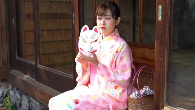 きつね面と浴衣の女性