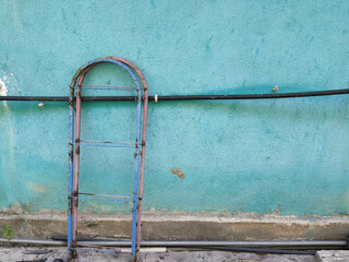 Scrap iron and black poly pipes on a stone wall
