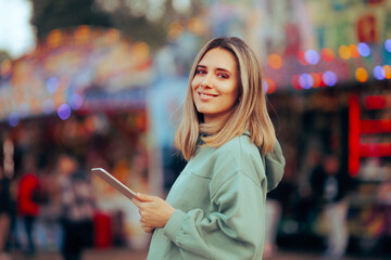 Happy Woman Holding a Pc Tablet Outdoors. Casual modern person using technology during travel
