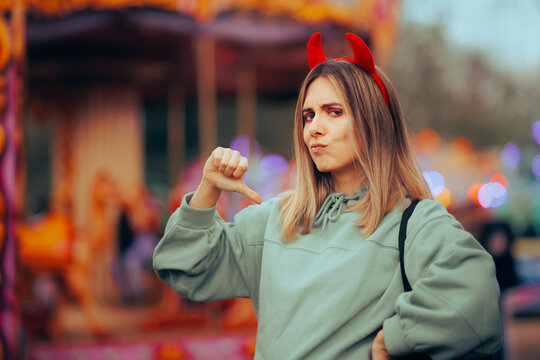 Mean Selfish Woman Wearing Devil Horns Pointing to Herself. Self-centered person thinking about herself in egocentric manner
