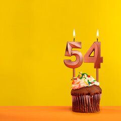 Candle with flame number 54 - Birthday card on yellow background