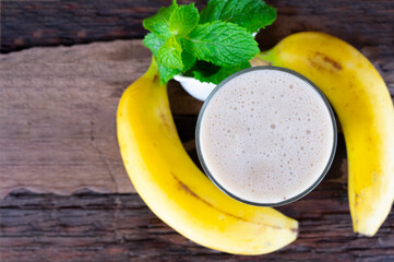 Banana fresh cocktail vanilla smoothies  fruit juice beverage healthy the taste yummy in glass drink episode good morning on wooden background from the top view.