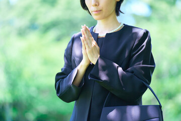 喪服姿で合掌する女性