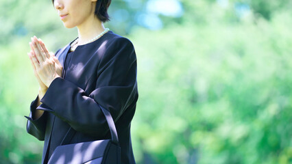 喪服姿で合掌する女性