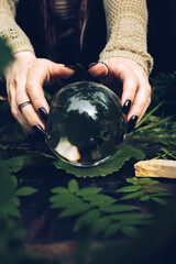 close up hands holding fortune-telling ball on a grass in the forest